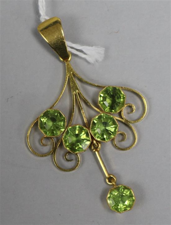 An 18ct gold openwork scroll pendant set with five large peridots, 52mm.